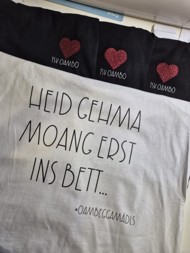 Text auf einem Kissenbezug: "Heid gehma moang erst ins Bett." Mit Herzmotiven.
