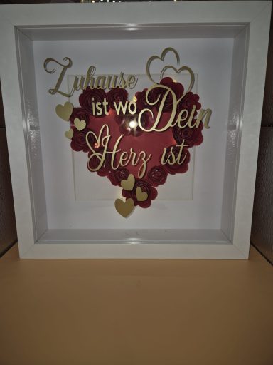 Dekorative Box mit dem Text "Zuhause ist wo Dein Herz ist" und Herzen in Gold und Rot.