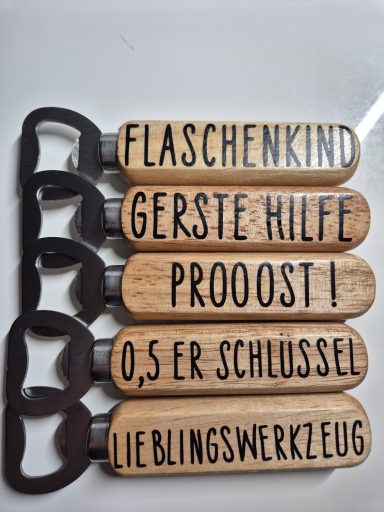 Fünf Flaschenöffner mit Holzgriffen und verschiedenen Aufschriften.